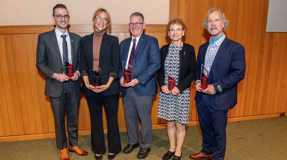 The five Stritch Alumni of the Year Award winners smiling and each holding a glass trophy.